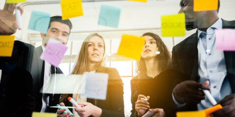 Group of successful business teamwork. Brainstorm meeting with colorful sticky paper note on glass wall for new ideas. Using agile methodology and do business. Brainstorming in a tech start-up office.