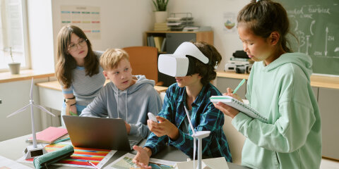 Diverse Teenagers Collaborating on Renewable Energy Project Using Virtual Reality