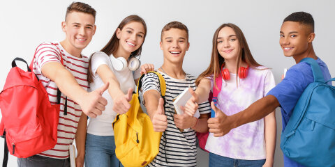 Cool teenagers showing thumb-up on white background